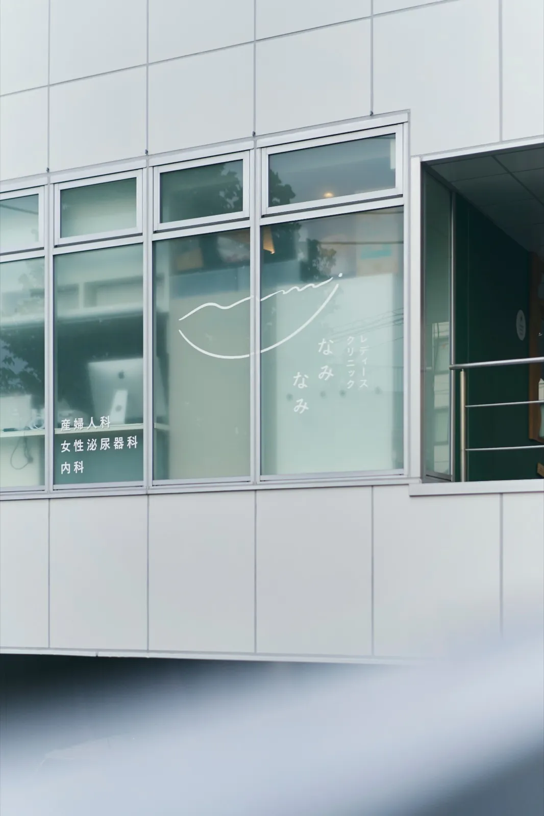 Exterior of Ladies Clinic Naminami, with the logo and departments shown on the window
